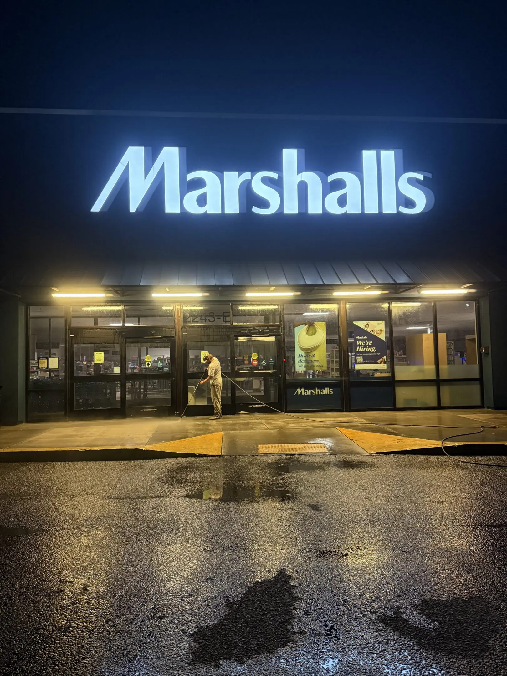 Night view of a Marshalls store entrance with illuminated sign.