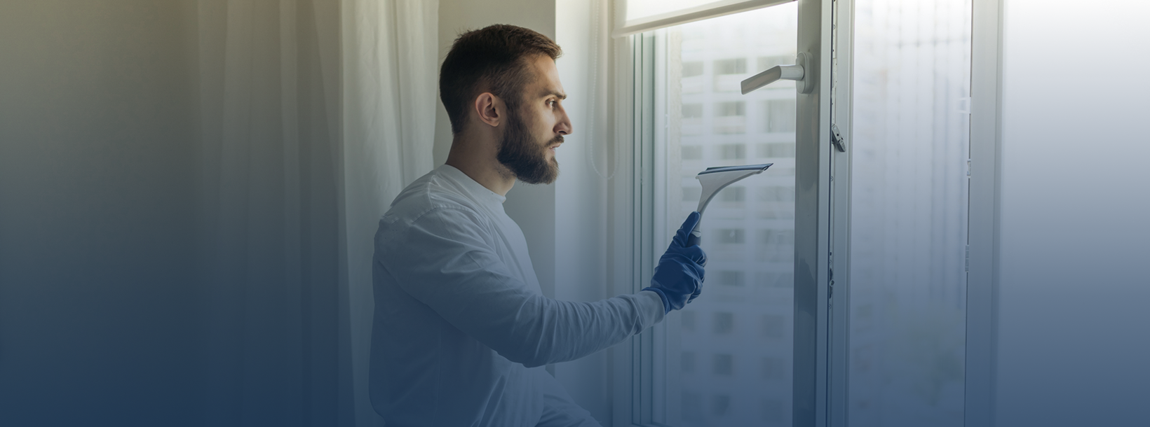 Man cleaning window with squeegee tool.