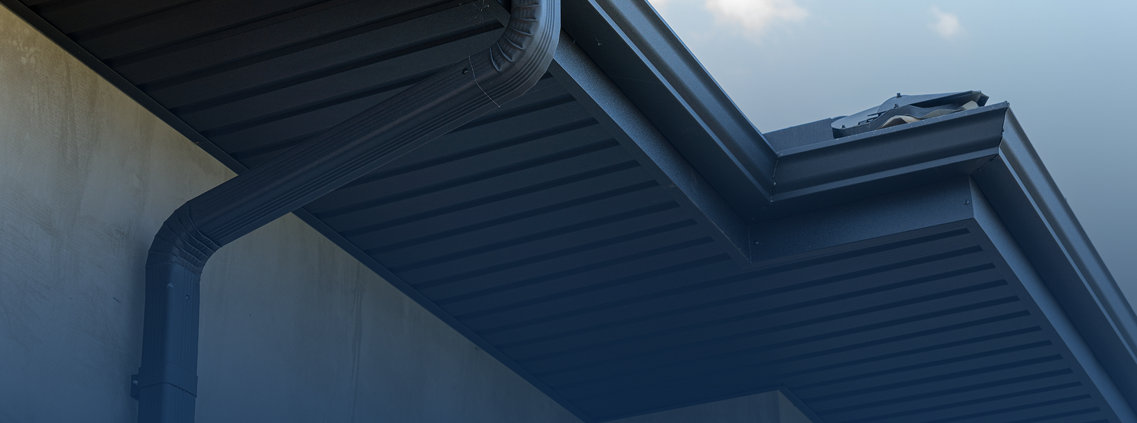 Modern gutter system on building roof edge.
