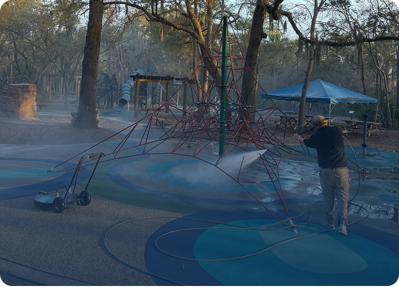 A person creating giant bubbles outdoors with a bubble wand.